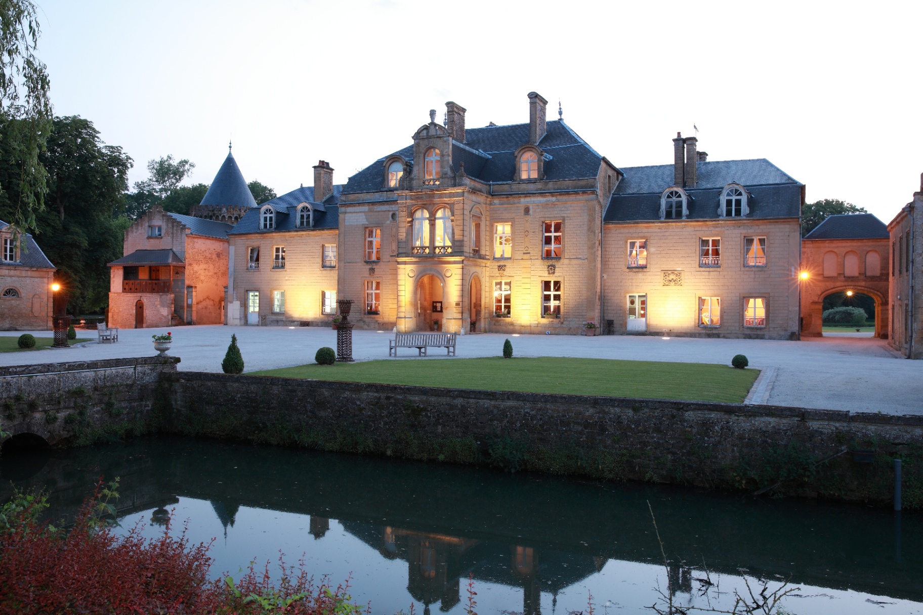 Façade du château et miroir d'eau au crépuscule