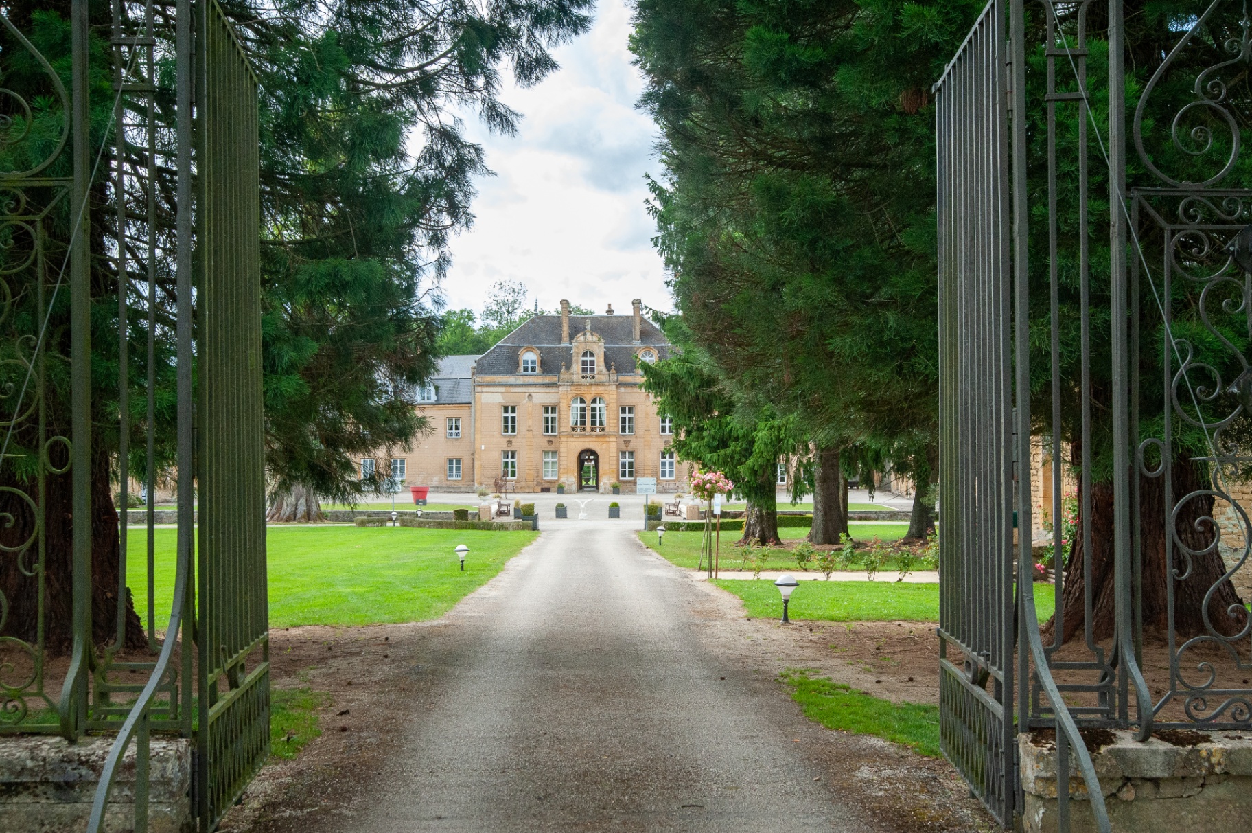 Allée d'entrée du château vue depuis le portail en fer forgé