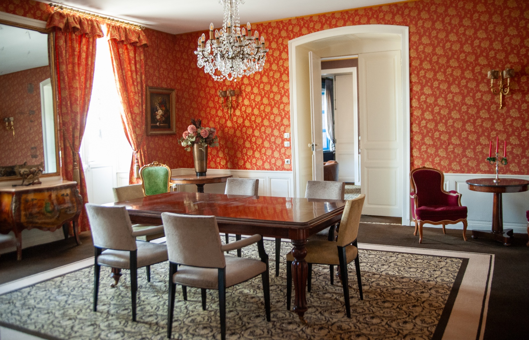Salle à manger d'apparat rouge et or avec mobilier d'époque et grand miroir doré